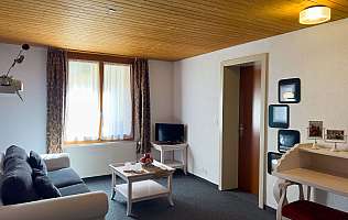 Salon confortable avec plafond à poutres en bois