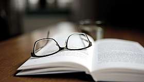 Brille auf offenem Buch
