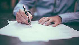 Hand schreibt auf Papier